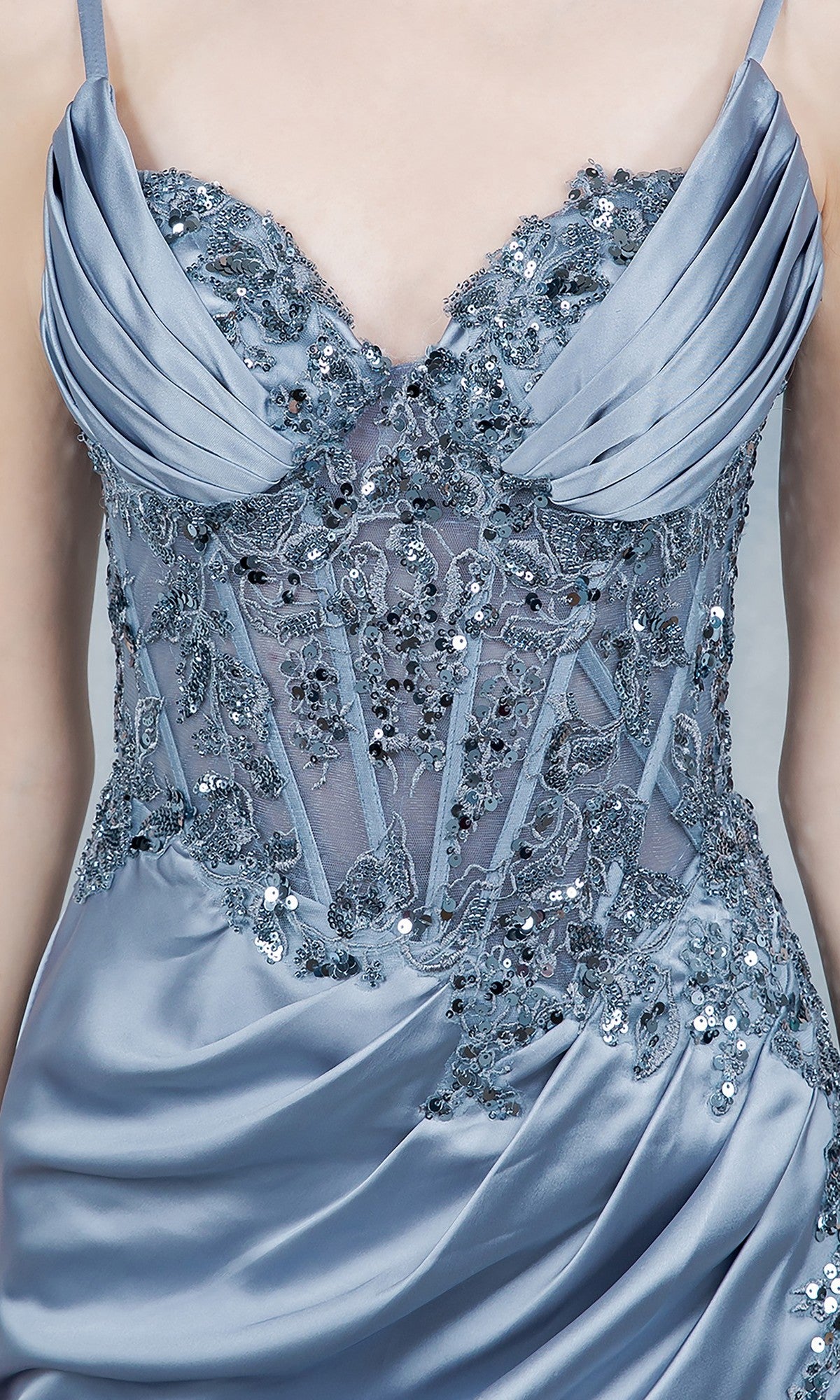 Close-up of Cinderella Couture 8377J, a blue satin long prom dress with sequin and lace embellishments, sheer panels, lace corset bodice, and pleated bodice detailing.